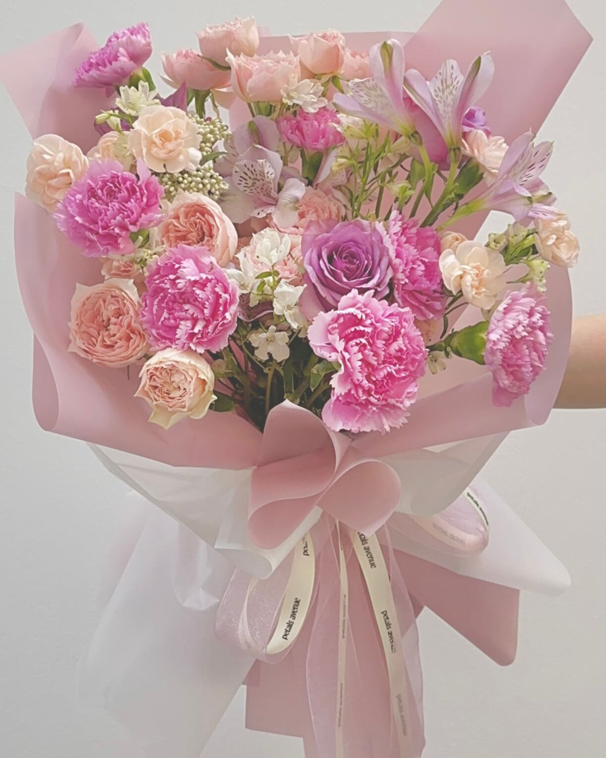 Delicate floral arrangement in Soft and Light theme, featuring carnations and spray roses in a romantic pastel palette.