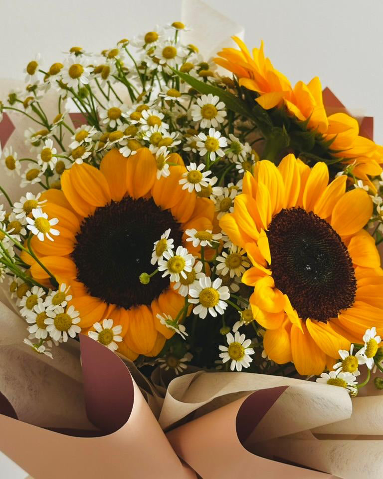 Cheerful bouquet featuring sunflowers and chamomile, symbolizing positivity and serenity