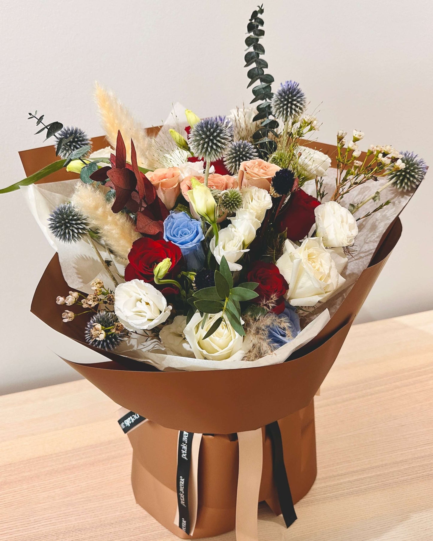 Oversized bouquet in deep autumn tones featuring burnt orange, burgundy, and muted greens, arranged with deluxe Chic filler flowers.