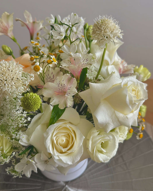 Close up Light-themed Omakase Bloom Box with soft, pastel-colored flowers and gentle greenery, perfect for subtle elegance.
