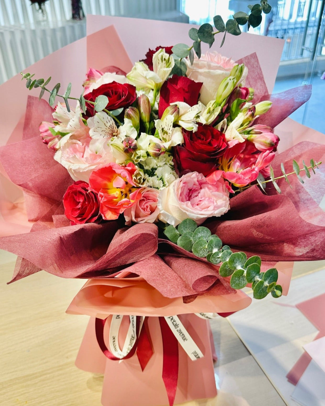Bright and Vibrant rose bouquet with 10 stalks of roses and chic filler flowers in pastel wrap