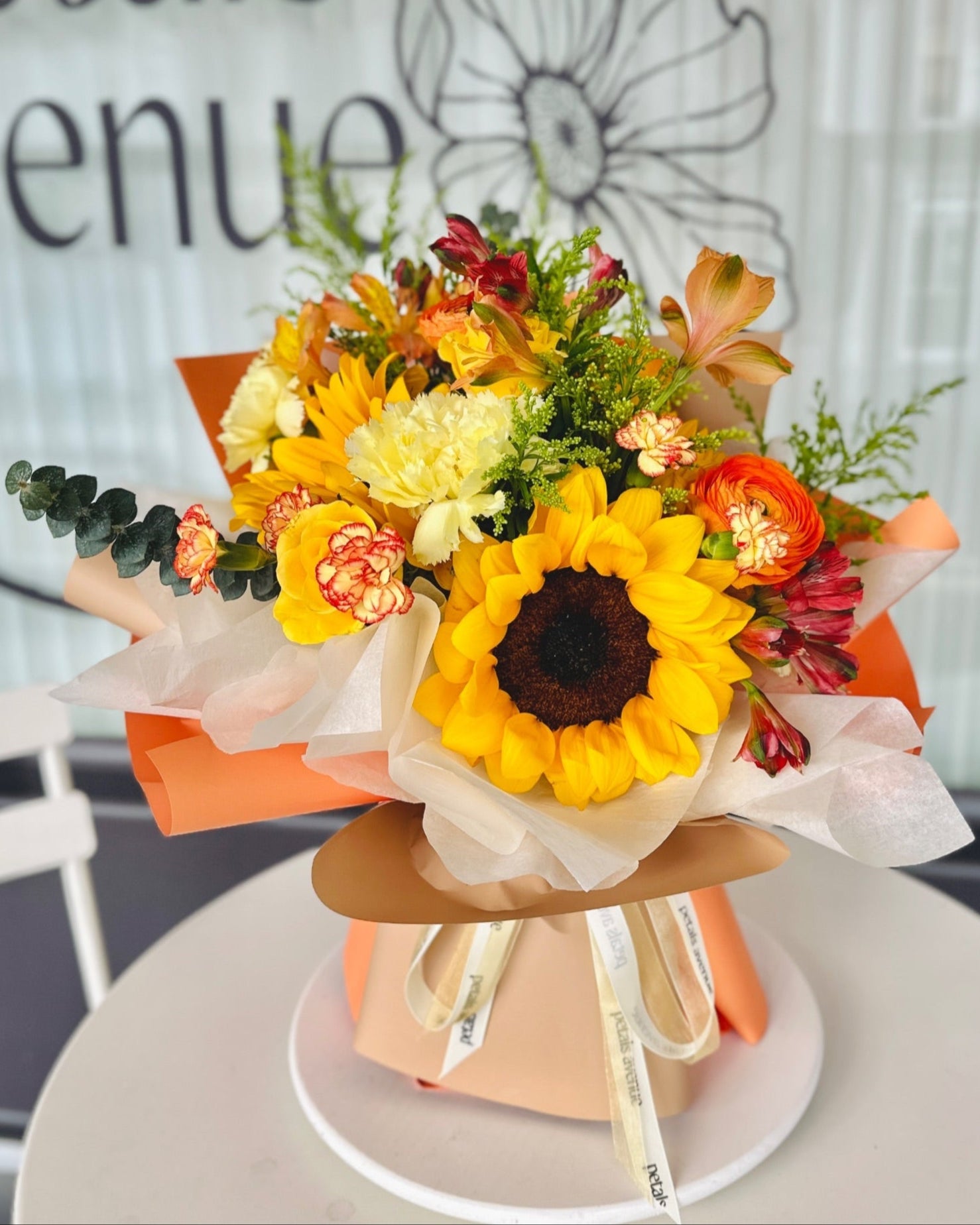 Image of sunflowers, tulips, and filler flowers in a Bright and Vibrant floral arrangement