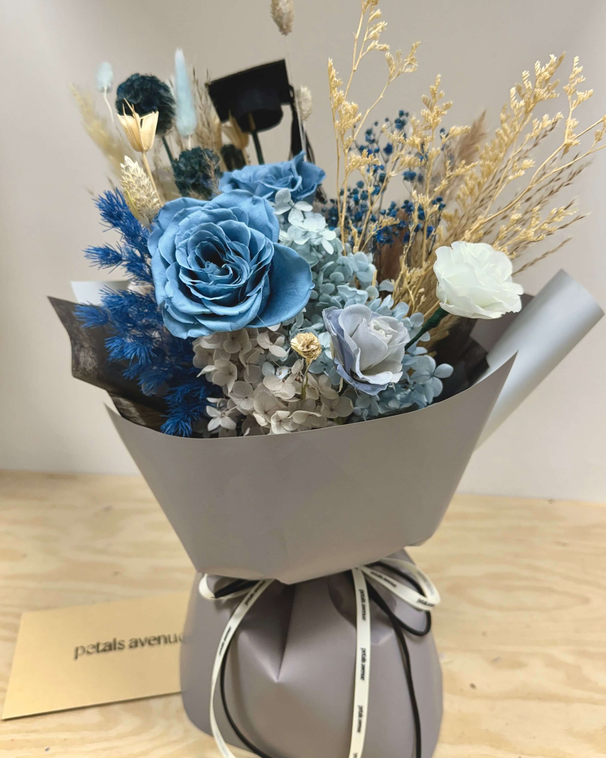 Bouquet of preserved flowers wrapped in gray paper