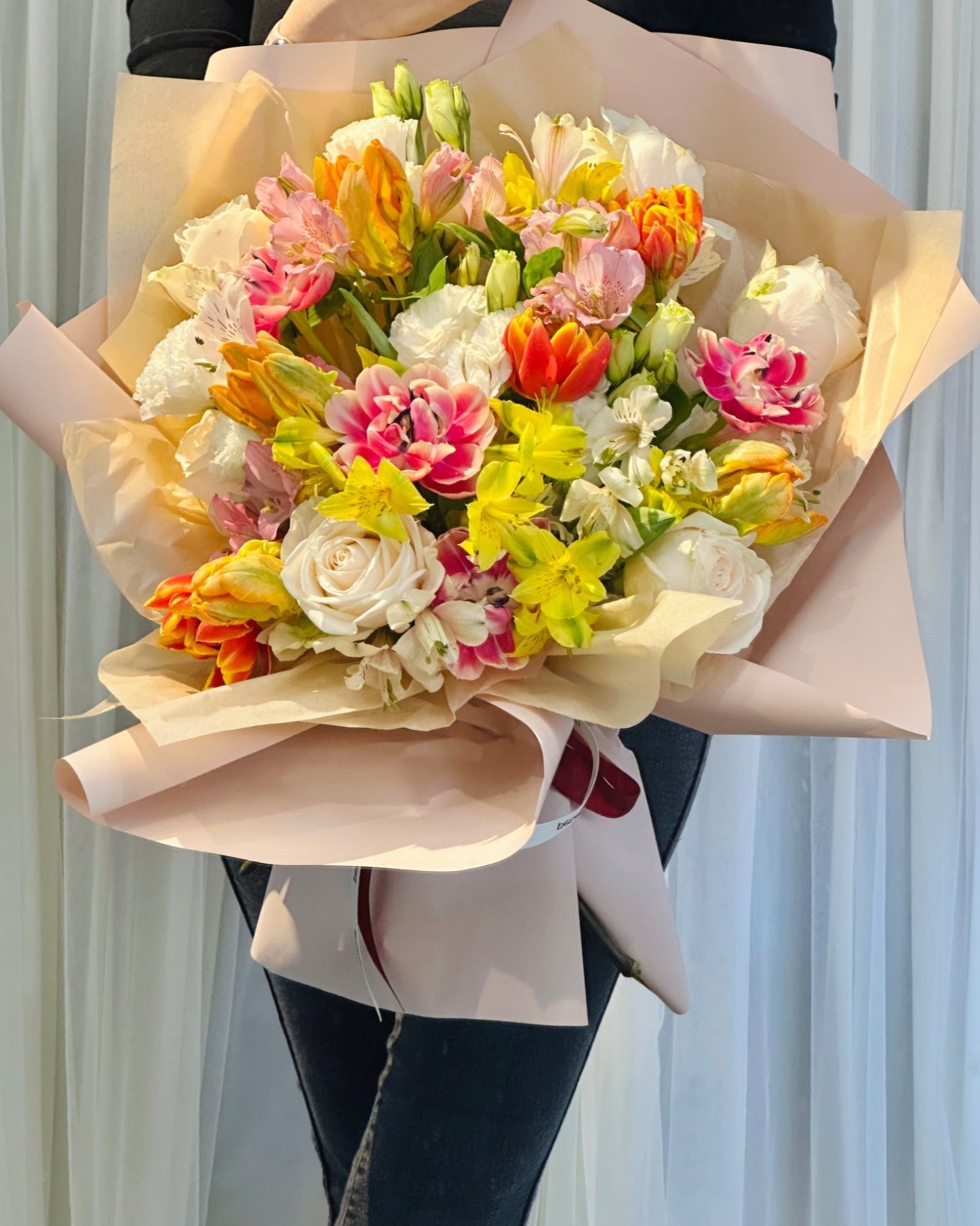Vibrant tulip arrangement with bold colours, paired with Chic filler flowers like spray roses and eustomas.