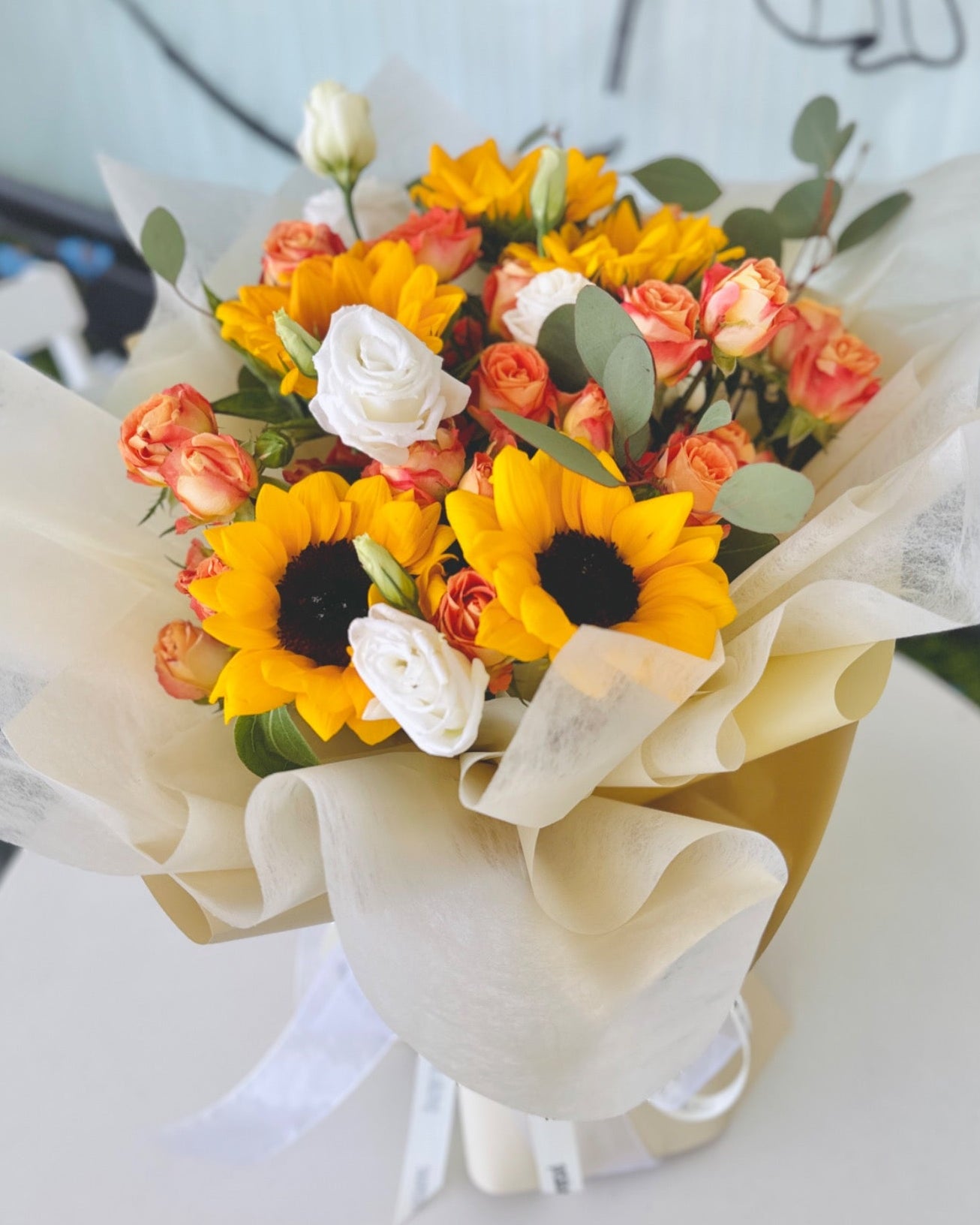 Bright and Vibrant sunflower bouquet with tulips and eustomas in a cheerful wrap