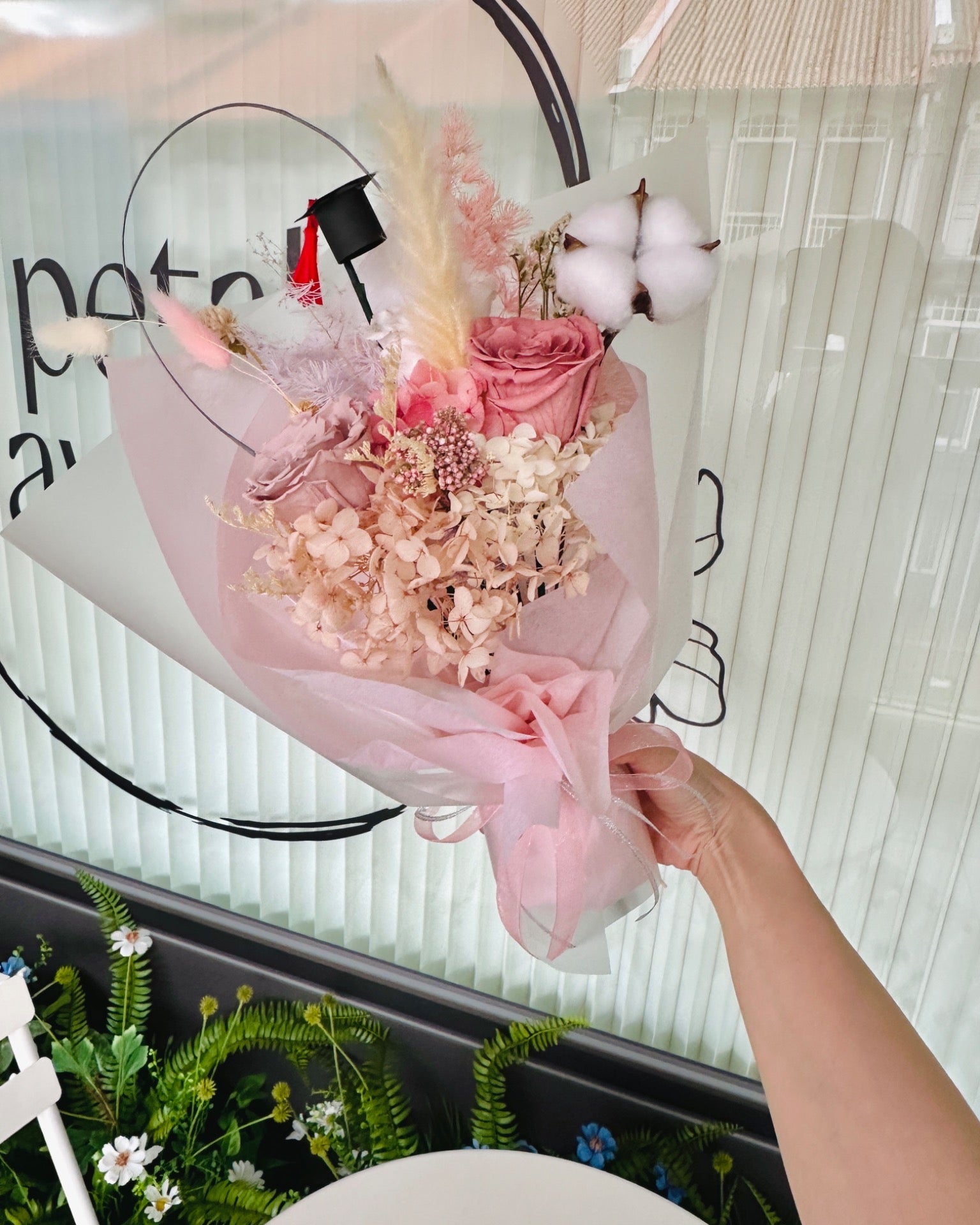 Elegant pink champagne-themed graduation bouquet with preserved flowers, perfect for celebrating achievement.