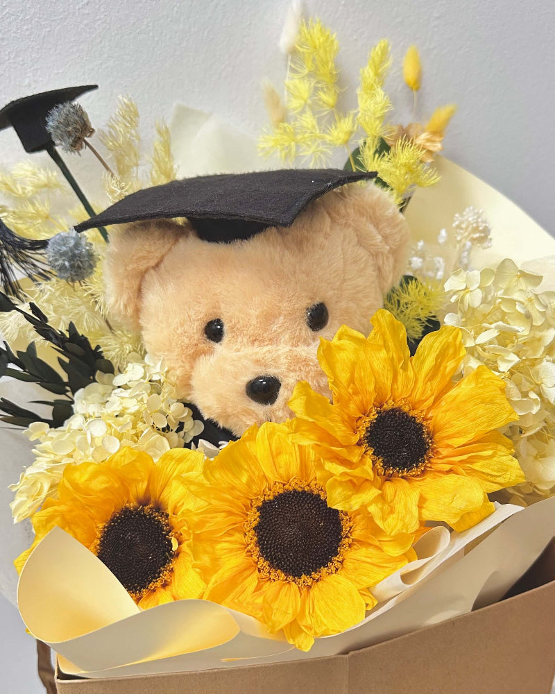 Graduation bouquet paired with a teddy bear for a memorable celebration gift