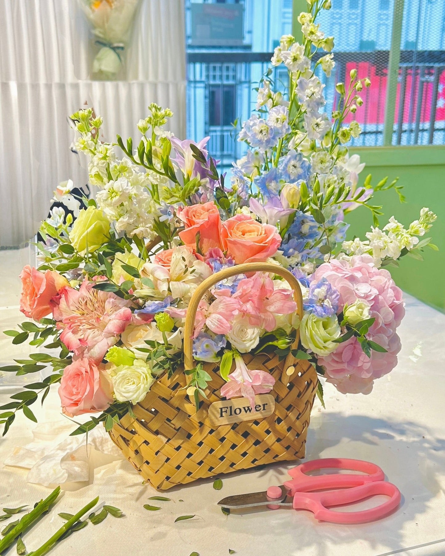 Medium-sized flower basket arrangement with seasonal blooms at private floral class