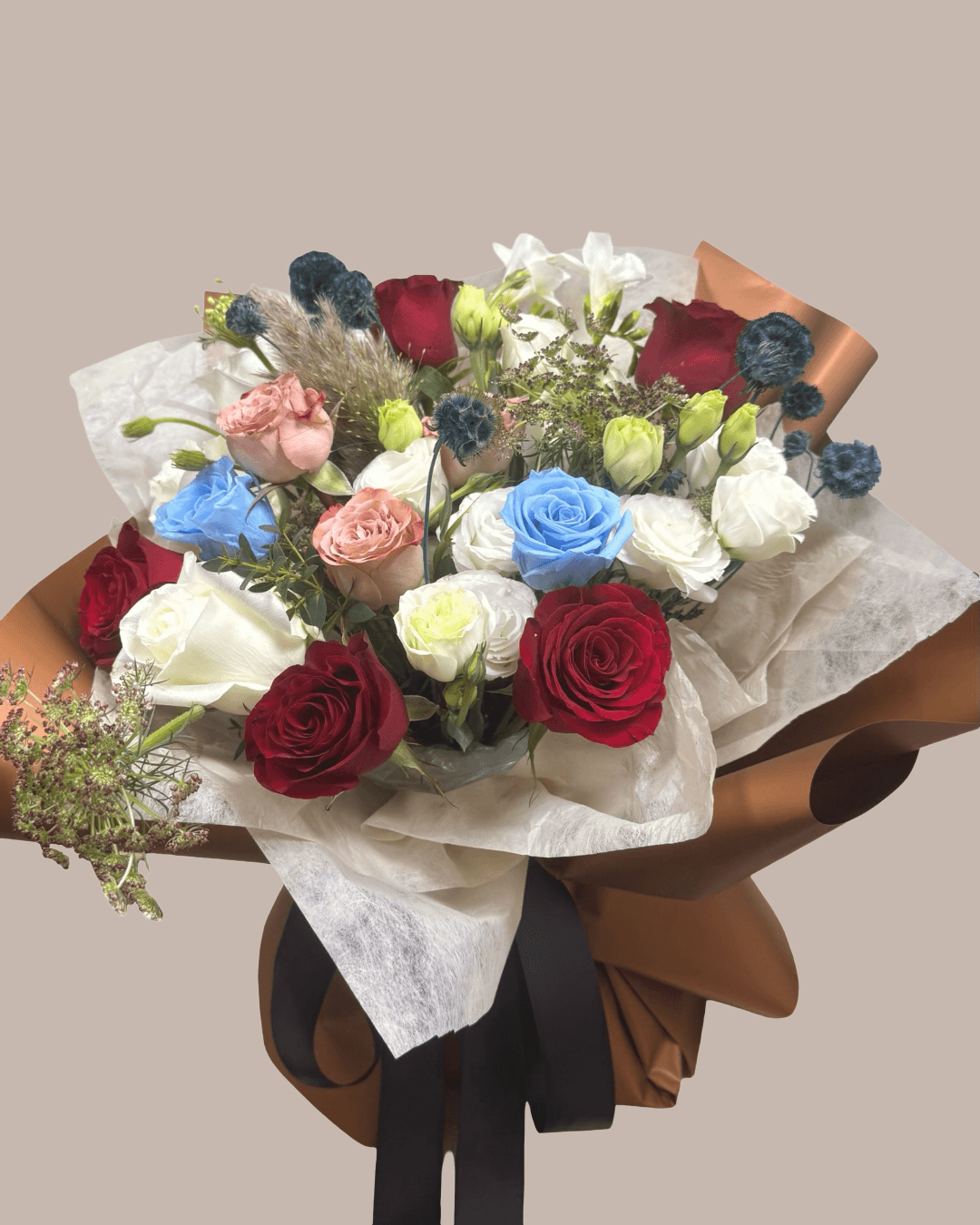 autumnal theme bouquet with blue, blush, red and white roses and other flowers
