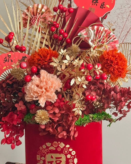 Decorative floral arrangement with red and gold elements on a neutral background