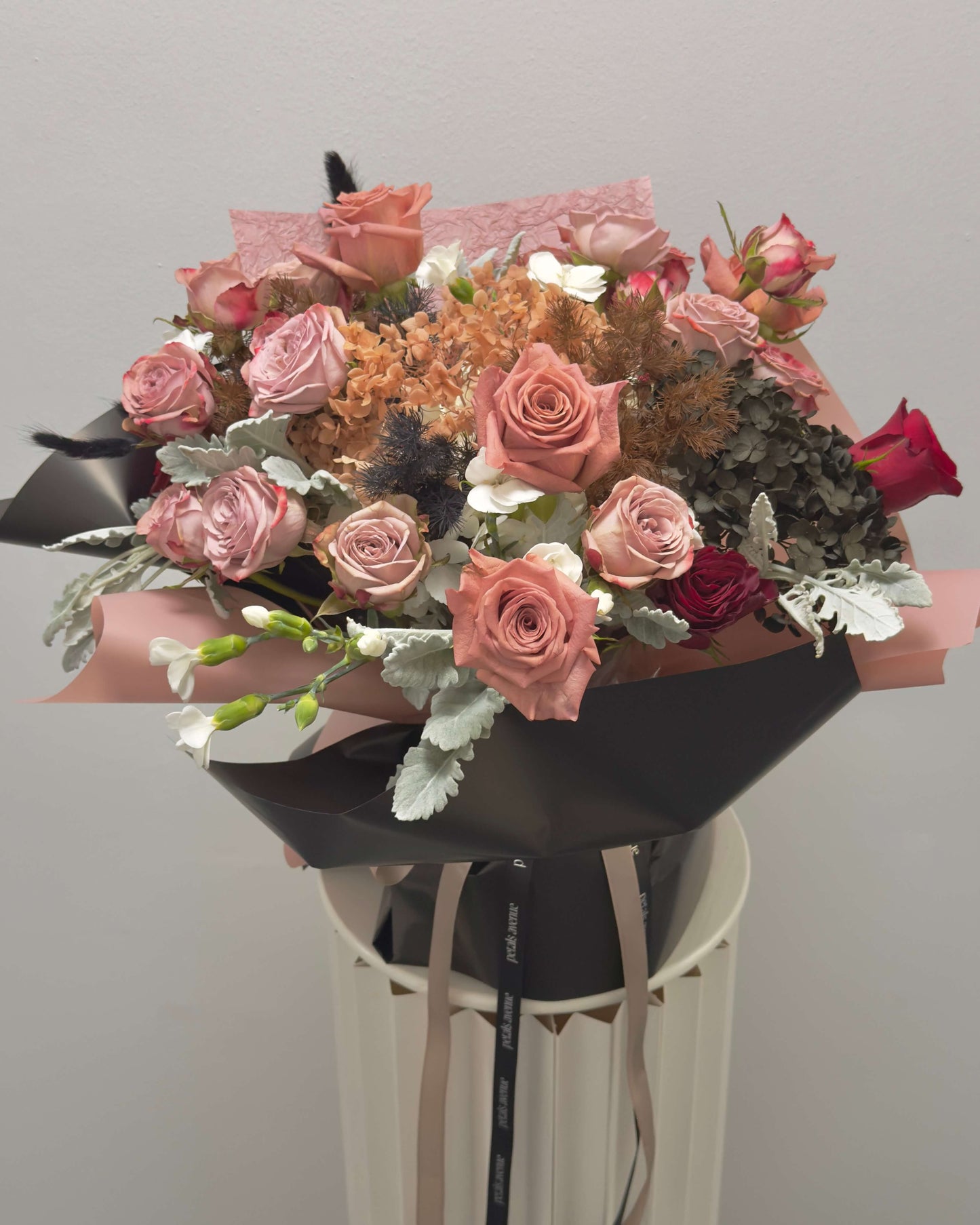 Bouquet of flowers with pink and red roses on a gray background
