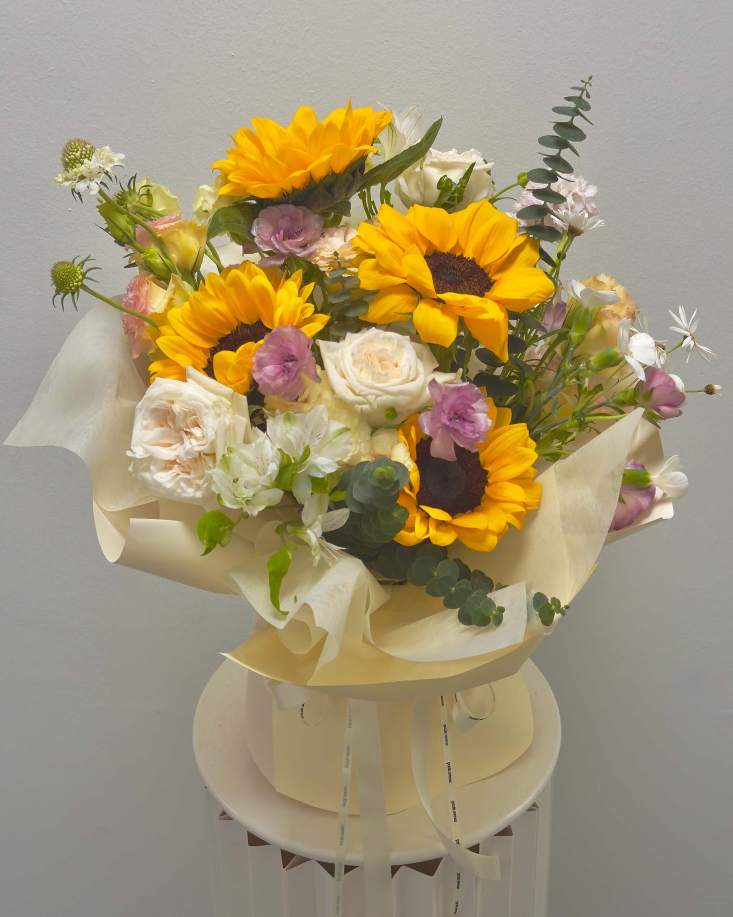 sunflower omakase bouque in soft and light theme with purple, pink and white accents 