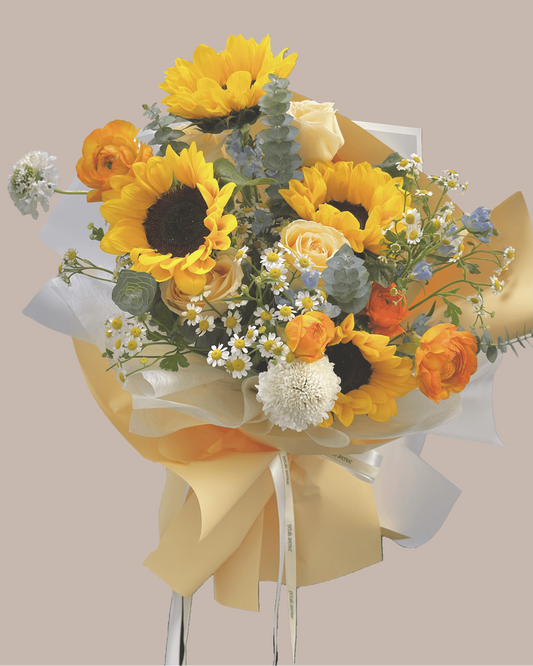 a sunflower bouquet with roses, rannunculus and other accompanying flowers 